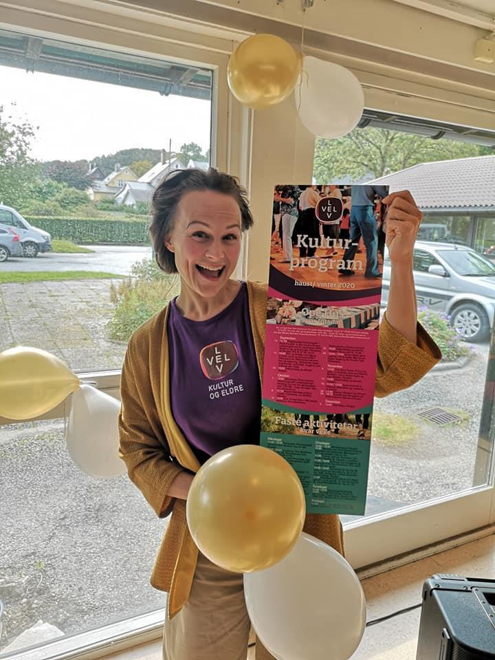 Bildet av samfunnskoordinator Martine Bortheim som held fram dei nye brosjyrene om ope hus. - Klikk for stort bilete
